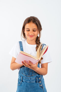 Smiling girl reading book in studio