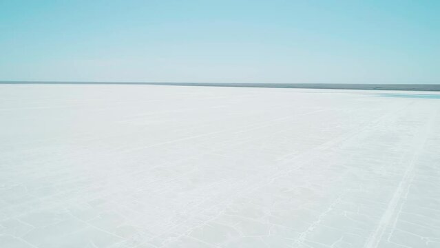 Aerial wide view of salt lake coast. Baskunchak in high tourist season at bright sunny day. Unique lake in the southwest of Russia, medicinal clay and mud deposite