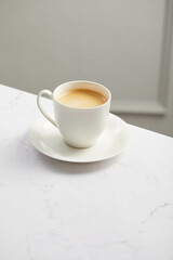 Cup of coffee, on white marble table
