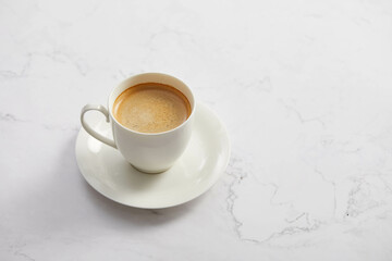 Cup of coffee, on white marble table
