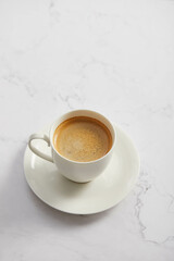 Cup of coffee, on white marble table