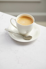 Cup of coffee, on white marble table