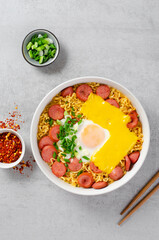 Ramen Noodles with Sausages, Egg, Melted Cheese and Scallion, Microwave Shin Ramyeon or Ramyun on Bright Background