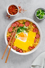 Ramen Noodles with Sausages, Egg, Melted Cheese and Scallion, Microwave Shin Ramyeon or Ramyun on Bright Background