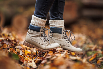 Leather hiking boot with knitted socks. Walking in autumn forest
