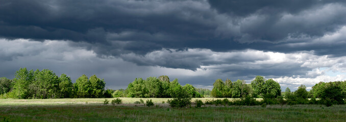 stormy dark clouds over meadows