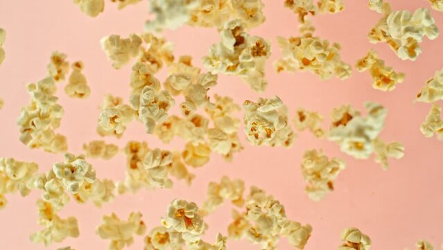 Super slow motion of rotating popcorn in the air. Isolated on colored background. Filmed on high speed cinema camera, 1000fps, placed on high speed cine bot, following the target. Speed ramp effect.