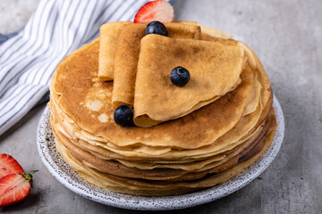 Large stack of traditional thin Russian pancakes on a plate close-up