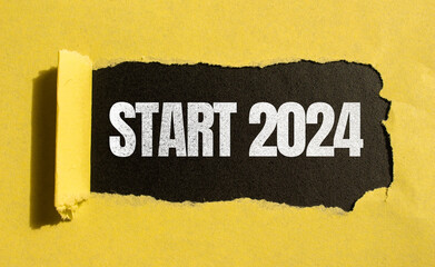 New Year 2024 symbol. Torn yellow paper with Start 2024 lettering.