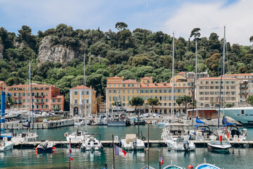Fototapeta na wymiar Nice, France - 01 June 2023: View of the port of Nice, moored yachts and boats, and the brightly colored facades of the surrounding houses