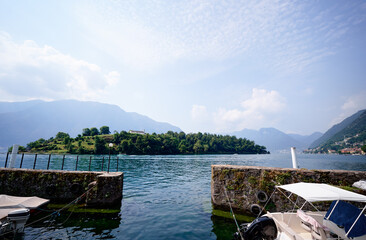 Beautiful scene of boats on lake Como in Italy. A big blue lake surrounded by green hills