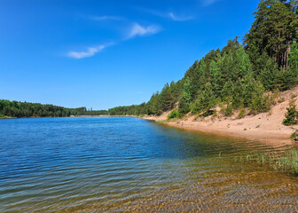 Transparent blue water in a Dubkalnu Reservoir among pine forests at Zilie Kalni (Blue Hills) Nature Park in the Ogre municipality, Latvia, Europe. Clean environment concept.