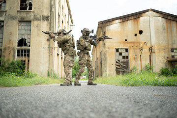 Special forces soldier in camouflage with a pair of weapons that are full of modern technology and...