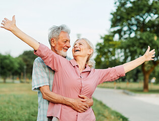 woman man senior couple happy retirement together elderly hug bonding park outdoor park fun smiling love old nature wife happiness active