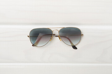 Sunglasses on wooden background, top view.