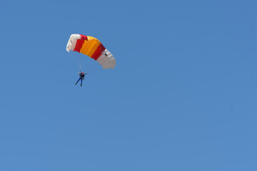 Parachutist man flies with colourful paraglider