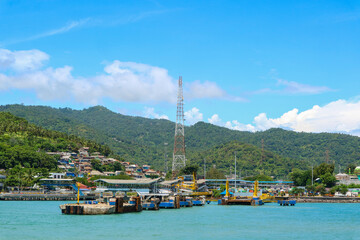 Panoramic view of harbor or port with communication or provider tower and village on hillside. Merak port in Banten, Indonesia.