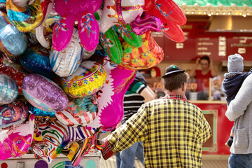 Ein Ballonverkäufer in Clownskostüm. 