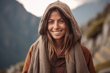 Close up portrait of a smiling young woman in a hood standing outdoors