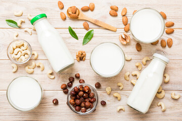 Set or collection of various vegan milk almond, cashew, on table background. Vegan plant based milk and ingredients, top view