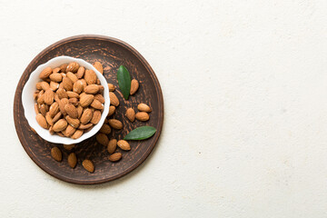 Fresh healthy Almond in bowl on colored table background. Top view