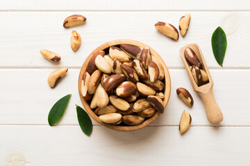Fresh healthy Brazil nuts in bowl on colored table background. Top view Healthy eating bertholletia concept. Super foods
