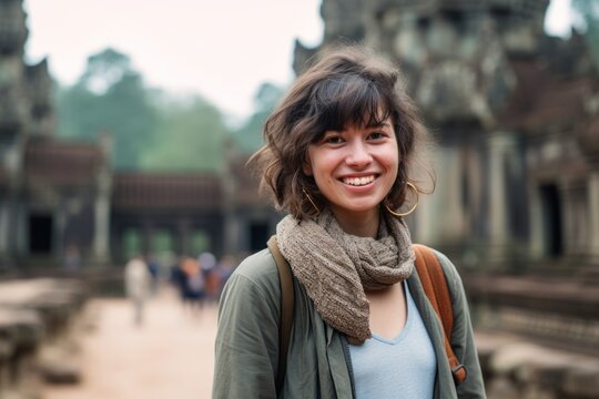 Portrait of a smiling young woman in front of Angkor Wat in Cambodia