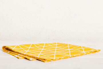 top view with yellow empty kitchen napkin isolated on table background. Folded cloth for mockup...