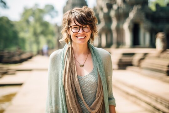 Portrait of happy young woman in front of Angkor Wat temple in Siem Reap, Cambodia