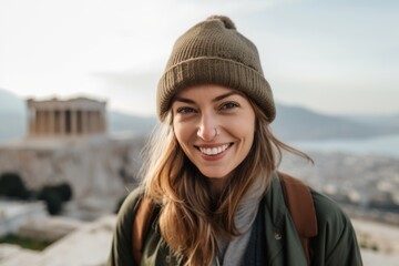 Image of a beautiful happy young woman tourist walking outdoors at the Acropolis.