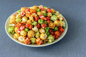 A rainbow of sweet popcorn in a plate on a tablecloth