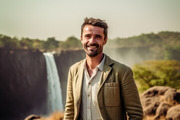 Group portrait photography of a grinning man in his 40s that is wearing a chic cardigan at the Victoria Falls in Livingstone Zambia . Generative AI