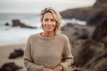 Fototapeta na wymiar Portrait of smiling woman with arms crossed on beach in the morning