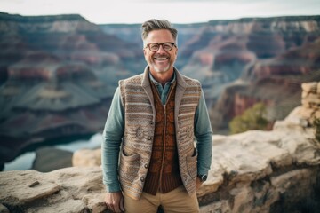 Lifestyle portrait photography of a grinning man in his 40s that is wearing a chic cardigan at the Grand Canyon in Arizona USA . Generative AI