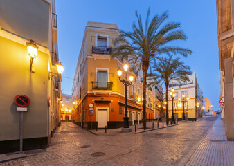 Traditional old narrow street in Cadiz at dawn. © pillerss
