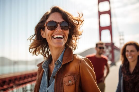 Lifestyle portrait photography of a grinning woman in her 40s that is smiling with friends at the Golden Gate Bridge in San Francisco USA . Generative AI