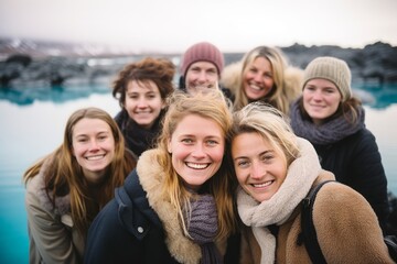 Obraz premium Portrait of smiling friends standing together at beach during cold winter day