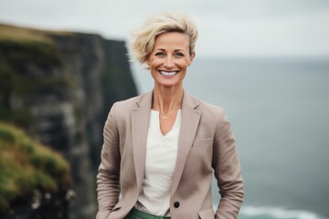 Fototapeta na wymiar Portrait of a happy senior businesswoman standing at the edge of a cliff