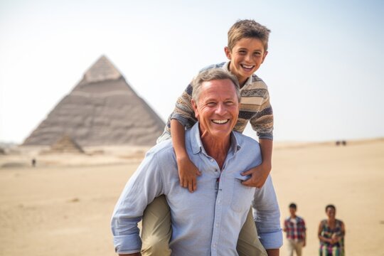 Grandfather and grandson having fun in front of the great pyramids