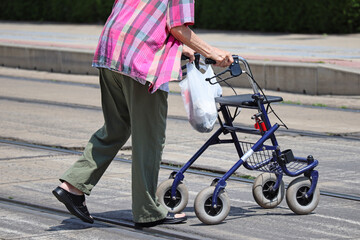 Senior women on the street with a walker - Powered by Adobe
