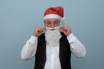 A man dresses up as Santa for a party. Portrait, blue background.