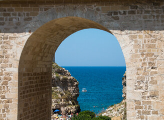Cala Monachile en el casco histórico de Polignano a Mare, Italia. Vista de la playa y el mar Adriático a través de los ojos del Puente de Borbón.
