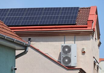 Solar panels on the roof and air conditioner on the wall of a building