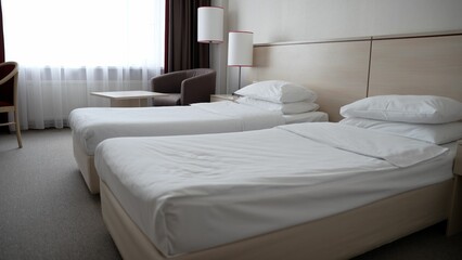 Two single beds in a cozy hotel room. Two elegant single beds in a spacious hotel room. A room with...