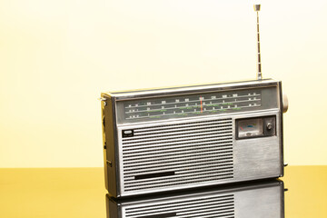 Old transistor radio on a yellow background