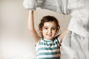 Cute little girl kid child making bed linen at home