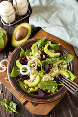 Vegan food, low calories dieting meal.Couscous with avocado, beet, green beans, spinach on a rustic wooden table.