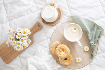 A cup of coffee and dessert with cream for breakfast. Morning in bed