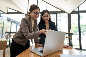 Business colleagues working on laptop. Working together on a project plan.