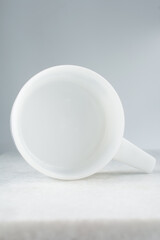 White ceramic ramekin with a handle, ceramic ovenware on marble tray
